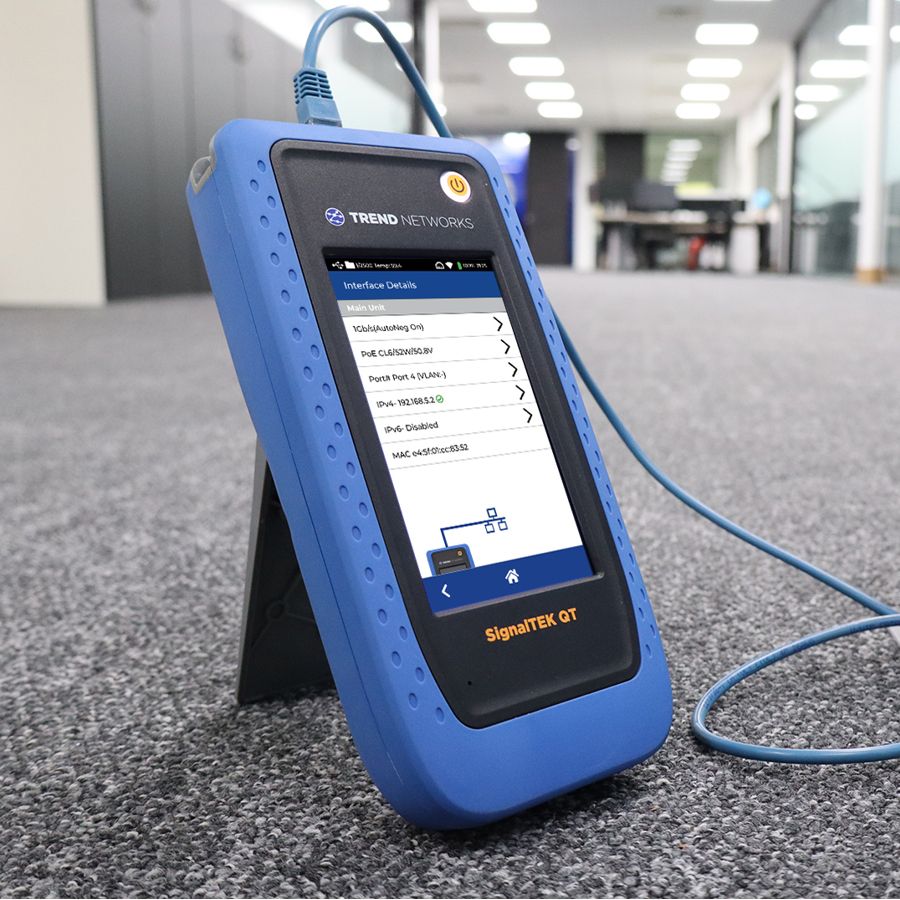 SignalTEK QT conectado a una toma de suelo en una oficina, calificando el enlace